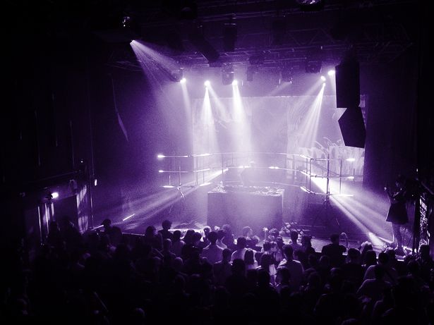 View of the venue during a Rave Records DJ set, light beams above the crowd